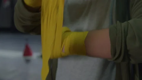 Boxer wraps a yellow boxer's wrap around his left arm. Stock Footage 236538023