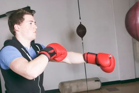 A Boxers doing some training on a punching bag at a gym Stock-Fotos