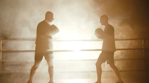 Boxers in dramatic silhouette exchanging punches in ring Stock Footage 308485254
