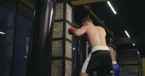Boxers training punching bag 4k video. Fighters blows jab cross punch fight Stock Footage 70405144