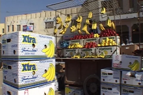 Boxes of bananas stacked up in front of fruit seller's cart. Stock Footage 86753822