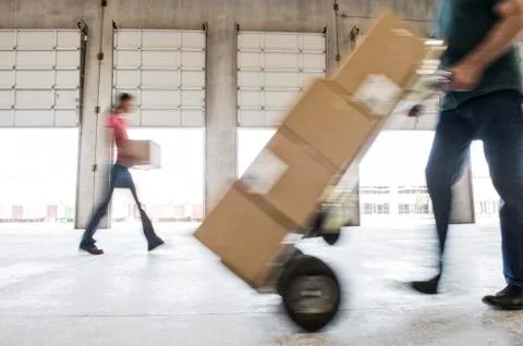 Boxes being moved into a new empty warehouse. Foto stock