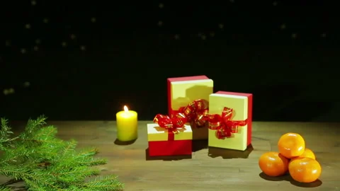 Boxes with Christmas presents and fragrant tangerines next to the Christmas tree Vidéo 97242297