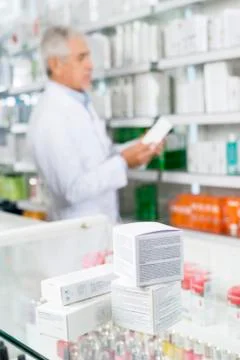 Boxes On Counter With Chemist Working In Pharmacy 写真素材