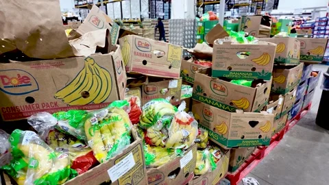 Boxes of Dole bananas are stacked on a pallet at a Costco UK wholesale store Stock Footage 327715519