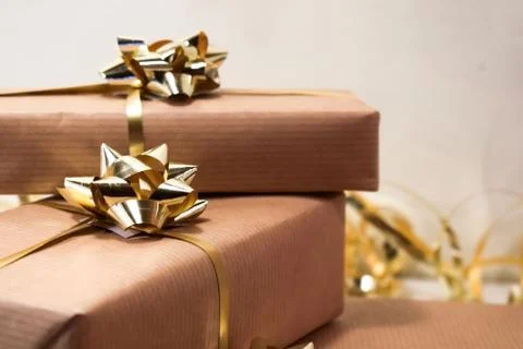 Boxes with gifts lie on a light surface. Gifts wrapped in craft paper. Stock Photos