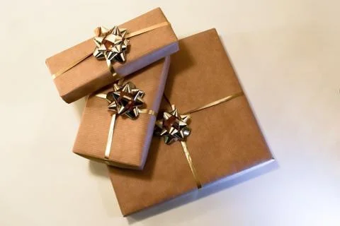 Boxes with gifts lie on a light surface. Gifts wrapped in craft paper. Stock Photos