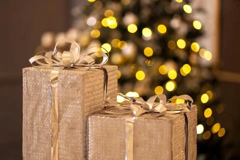 Boxes with gifts in silver wrapping on a background of christmas lights Stock Photos