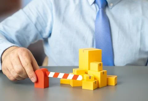 Boxes of goods and a barrier. Border control and customs regulation of trad.. Stockfoto's