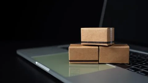 Boxes on a laptop keyboard on dark background. Ideas about online shopping,.. Stock Photos