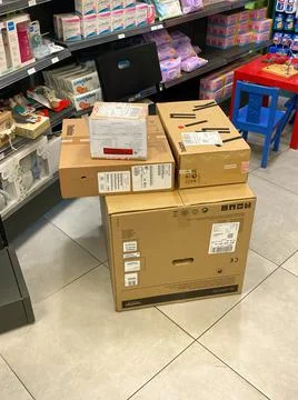 Boxes with Lenovo personal computer and Brother laser printer on the floor of 스톡 사진