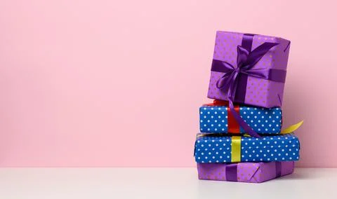 Boxes packed in festive blue paper and tied with silk ribbon on white backgro Stock Photos