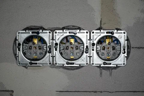 Boxes with power electric sockets installed in new house building empty wal.. Foto stock