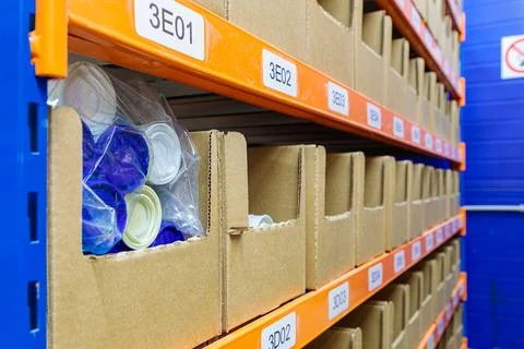Boxes on racks in a warehouse of goods close-up. Stock Photos