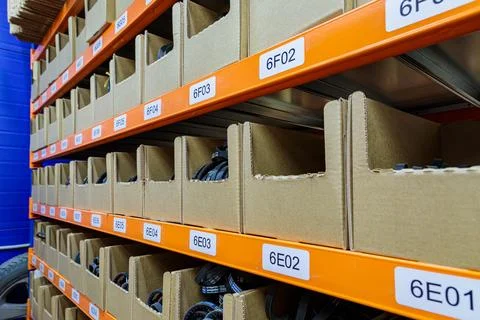Boxes on racks in a warehouse of goods close-up. Stock Photos