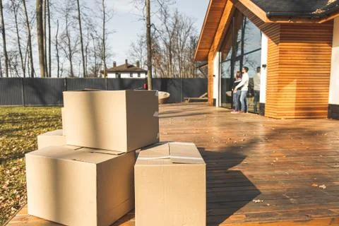 Boxes with things for moving on the background of a new house. concept of moving Stock Photos