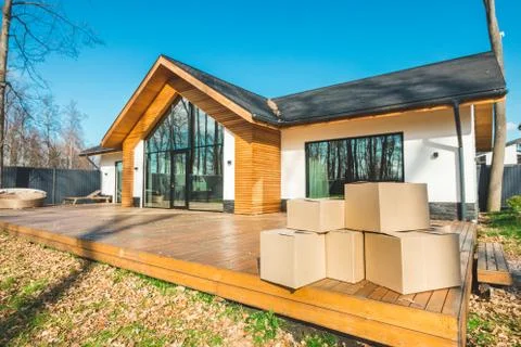 Boxes with things for moving on the background of a new house. concept of moving Stock Photos