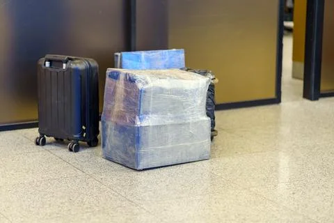 Boxes wrapped in polyethylene for checking in the luggage of the aircraft are Stock Photos