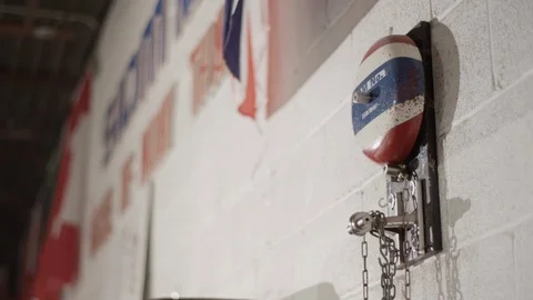 Boxing bell on a wall with flags waving in the background 스톡 동영상 104548641