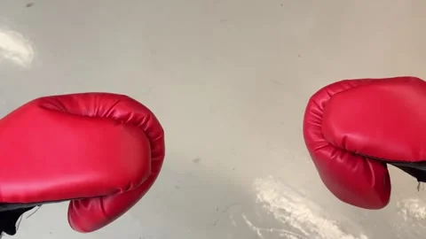 Boxing gloves collide in slow motion, top view, red gloves on white floor Stock Footage 306454025