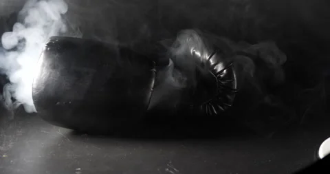 Boxing gloves fall and bounce smoke pouring around boxing gloves isolated Stock Footage 205043480