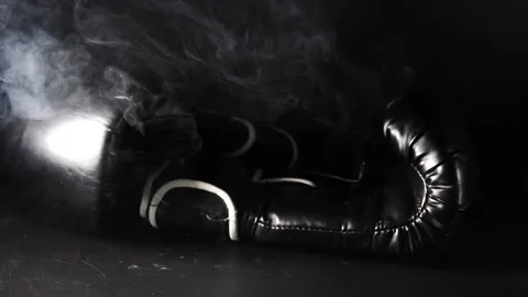 Boxing gloves falling a slow motion through thick smoke isolated on black Vidéo 205043782