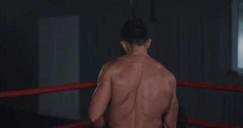 In the boxing ring athletic guy with perfect body get ready to start his intense Stock Footage 117053871