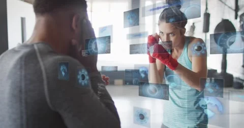 Boxing trainer holding pads while trainee moving and landing jabs, HUD panels Stock Footage 323479731
