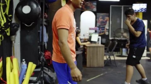Boxing training session with people practicing punches in an indoor gym in Stock Footage 343926788