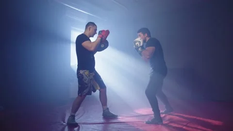 Boxing training with a trainer in the hall. Two athletes practice kicks Vídeos de archivo 236538938