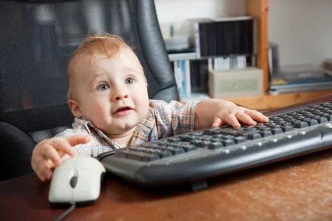 Boy, 10 months, using a computer mouse and keyboard Foto stock