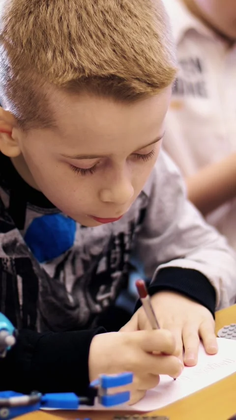 The boy of 10 years, draws a drawing, a project of a robot model, a machine, Stock Footage 314791539