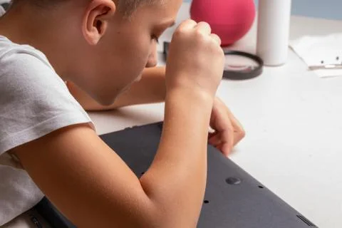 A boy of 10 years old is sorting a laptop for cleaning and maintenance. Selec Stock Photos