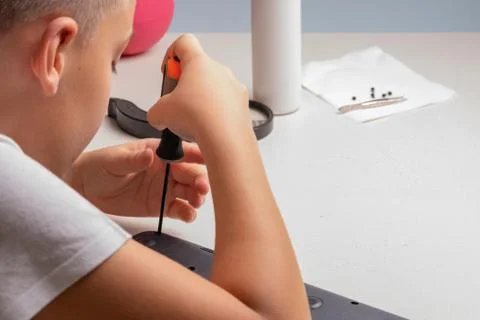A boy of 10 years old is sorting a laptop for cleaning and maintenance. Selec Stock Photos