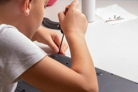 A boy of 10 years old is sorting a laptop for cleaning and maintenance. Selec Stock Photos