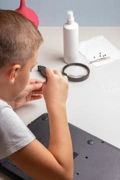 A boy of 10 years old is sorting a laptop for cleaning and maintenance. Selec Stock Photos