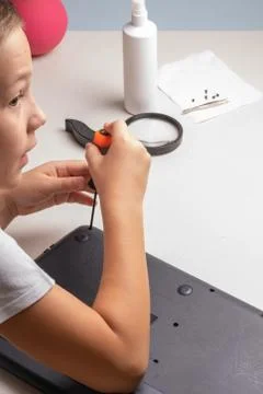 A boy of 10 years old is sorting a laptop for cleaning and maintenance. Selec Stock Photos