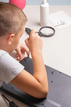 A boy of 10 years old is sorting a laptop for cleaning and maintenance. Selec Stock Photos