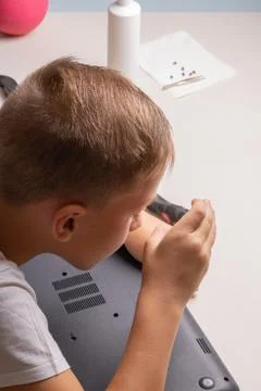 A boy of 10 years old is sorting a laptop for cleaning and maintenance. Selec Stock Photos