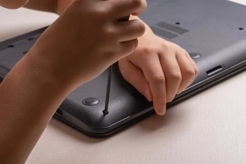 A boy of 10 years old is sorting a laptop for cleaning and maintenance. Selec Stock Photos