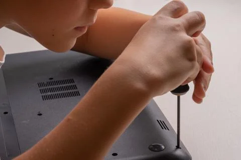 A boy of 10 years old is sorting a laptop for cleaning and maintenance. Selec Stock Photos