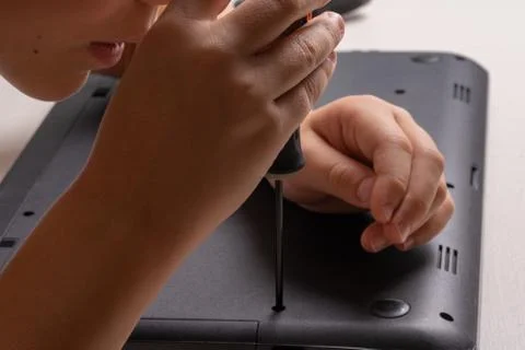 A boy of 10 years old is sorting a laptop for cleaning and maintenance. Selec Stock Photos