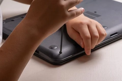 A boy of 10 years old is sorting a laptop for cleaning and maintenance. Selec Stock Photos