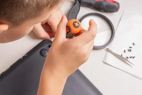 A boy of 10 years old is sorting a laptop for cleaning and maintenance. Selec Stock Photos