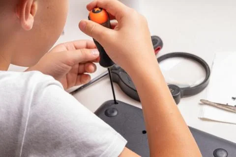 A boy of 10 years old is sorting a laptop for cleaning and maintenance. Selec Stock Photos