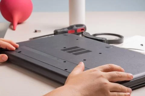 A boy of 10 years old is sorting a laptop for cleaning and maintenance. Selec Foto stock