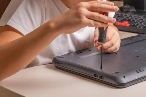 A boy of 10 years old is sorting a laptop for cleaning and maintenance. Selec Stock Photos