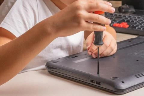 A boy of 10 years old is sorting a laptop for cleaning and maintenance. Selec Foto stock
