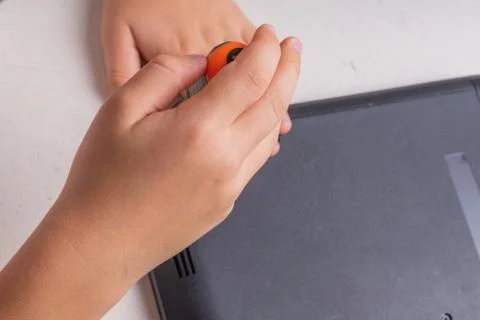 A boy of 10 years old is sorting a laptop for cleaning and maintenance. Selec Stock-Fotos