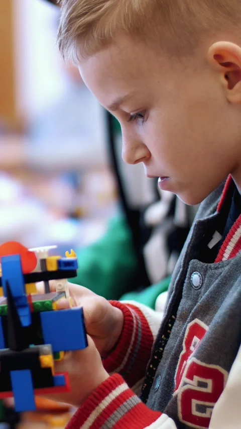 The boy of 10 years, plays in the designer from cubes, plates, circuits, wires. Stock Footage 314657457